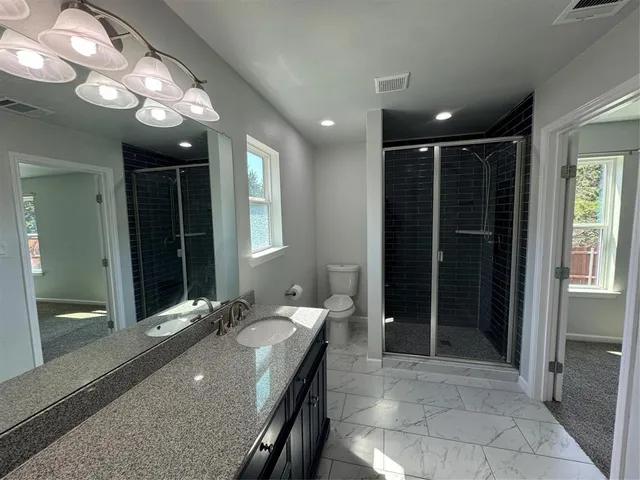a bathroom with a granite countertop sink a large mirror and a shower