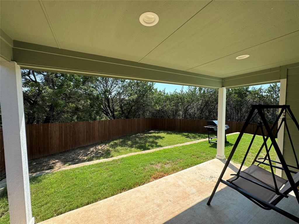 4720 Evening View Drive Granbury, TX 76048 - Photo 24 of 25 a view of backyard with a patio and a garden