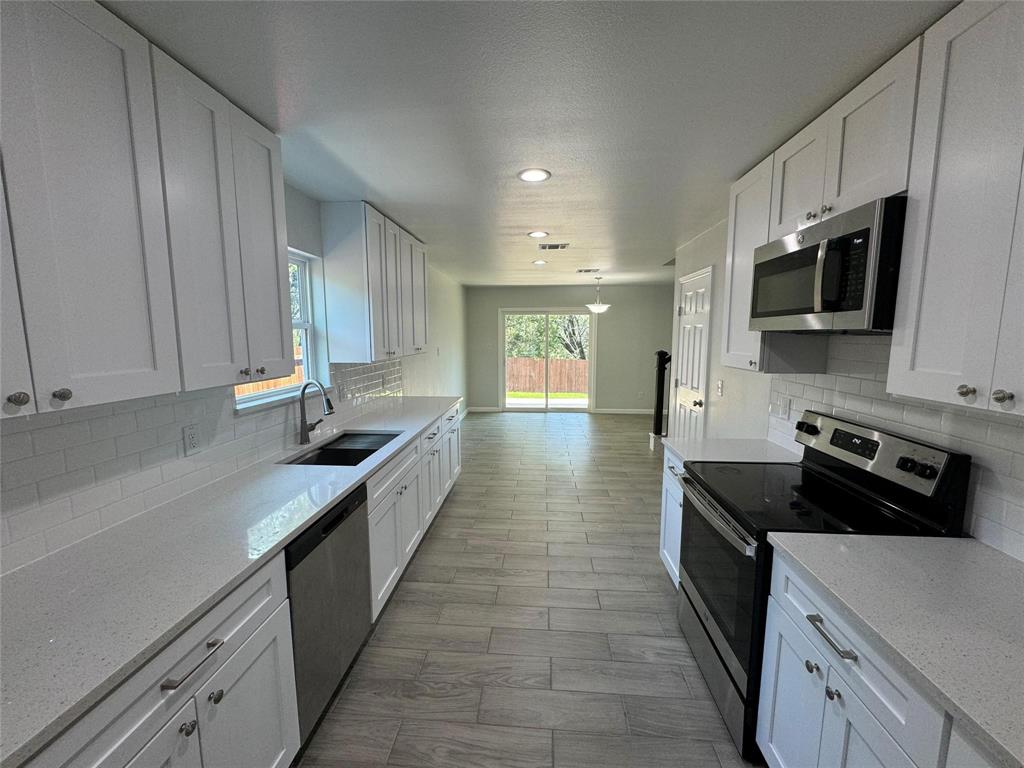 4720 Evening View Drive Granbury, TX 76048 - Photo 7 of 25 a kitchen with stainless steel appliances a sink dishwasher a stove top oven a refrigerator and white cabinets