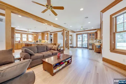 a living room with furniture ceiling fan and a wooden floor