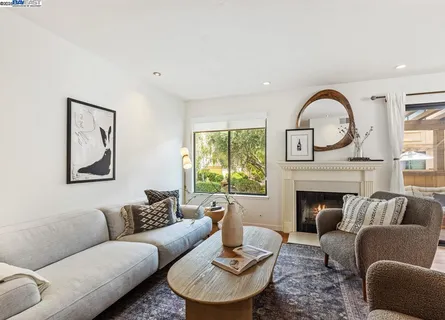 a living room with furniture a fireplace and a large window