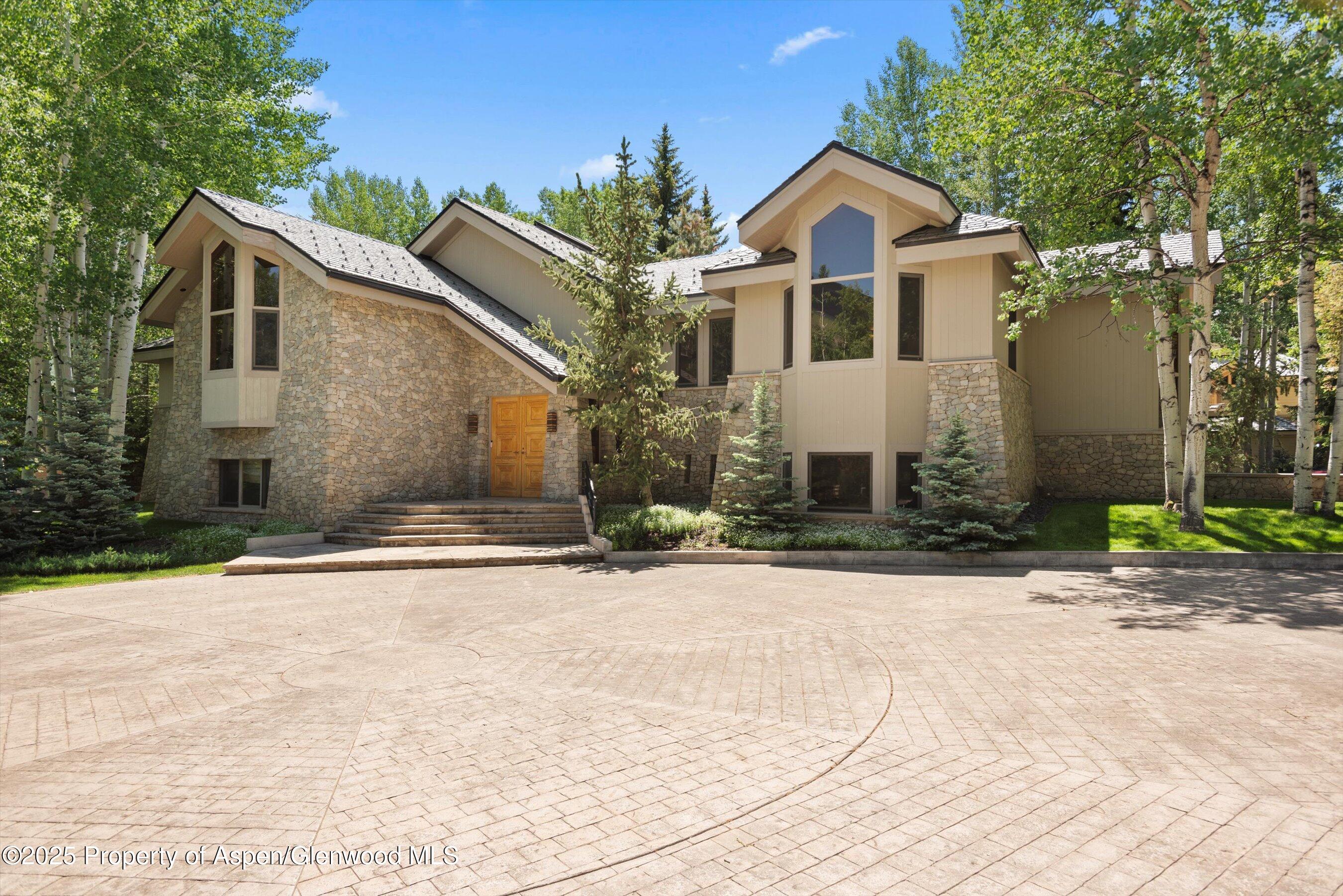 800 Roaring Fork Road Aspen, CO 81611 - Photo 1 of 37 a front view of a house with a yard and garage