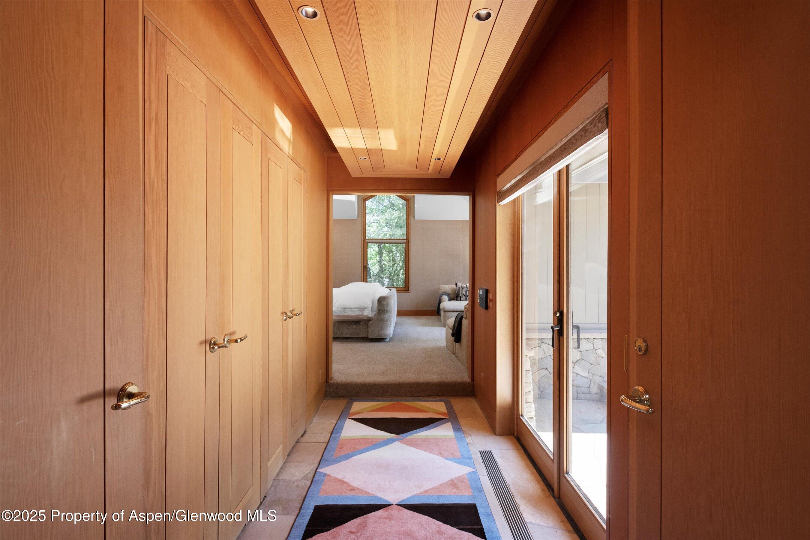 800 Roaring Fork Road Aspen, CO 81611 - Photo 17 of 37 a bedroom with furniture and large windows
