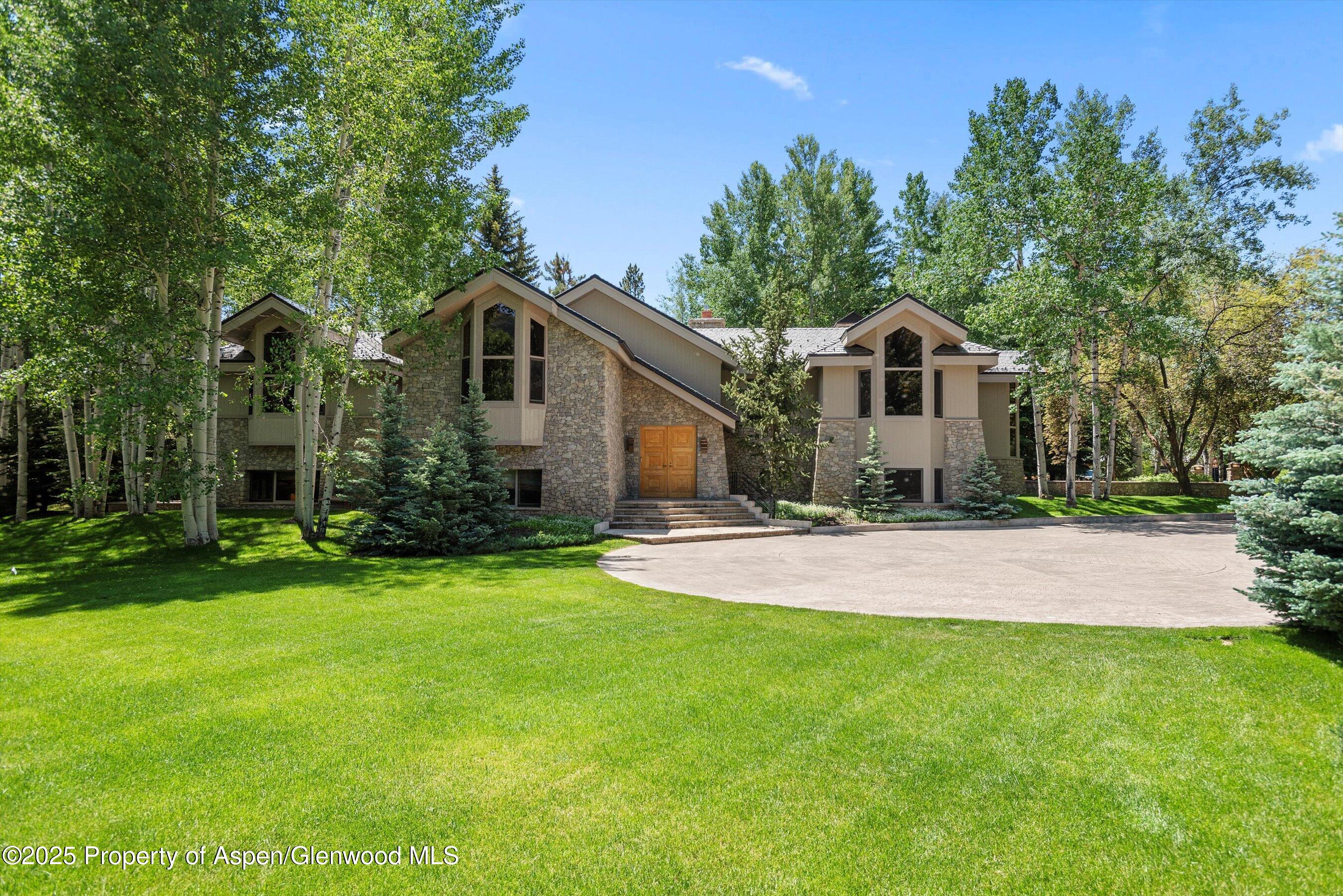 800 Roaring Fork Road Aspen, CO 81611 - Photo 2 of 37 a front view of a house with a yard and trees