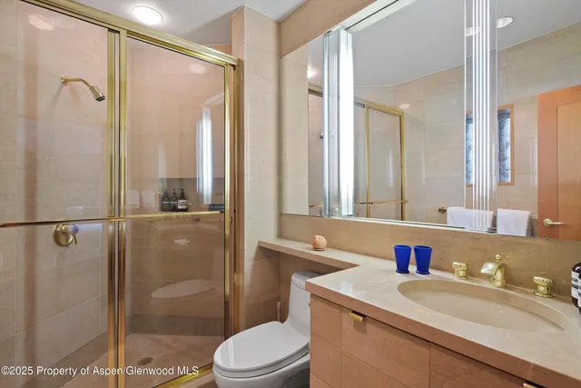 a bathroom with a granite countertop sink mirror toilet and shower