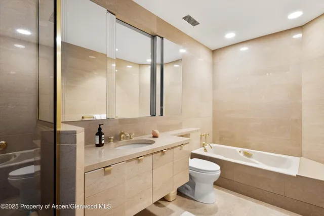 a bathroom with a granite countertop sink toilet a large mirror and shower