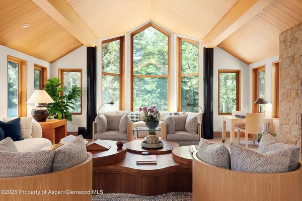 a living room with couches and a large window with garden view