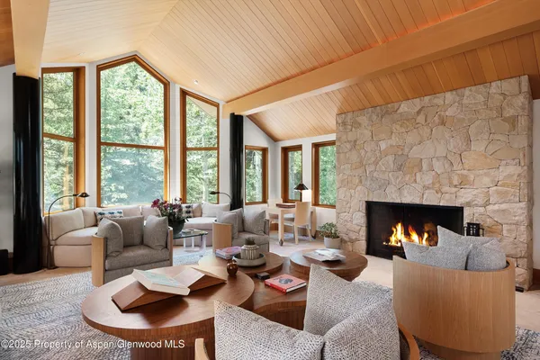 a living room with furniture fireplace and a large window