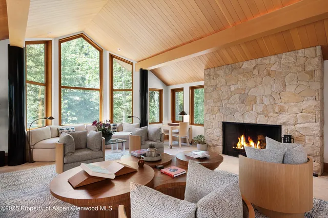 a living room with furniture fireplace and a large window
