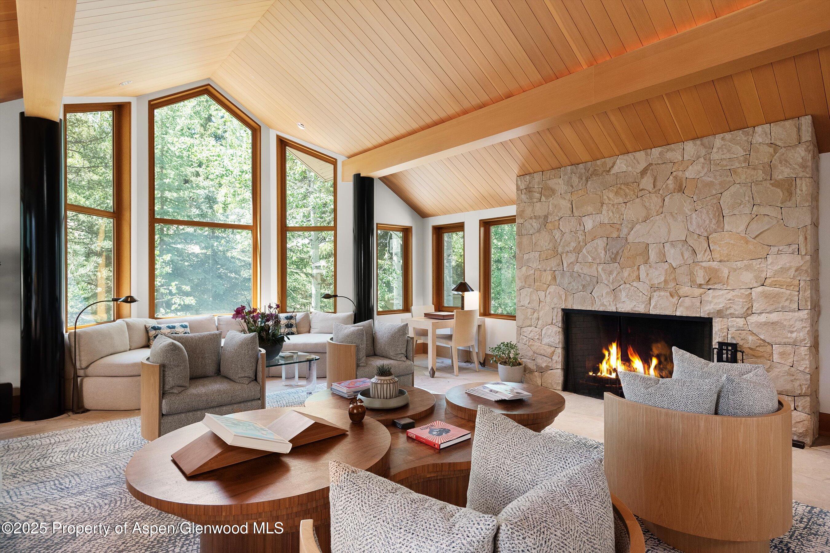 800 Roaring Fork Road Aspen, CO 81611 - Photo 4 of 37 a living room with furniture fireplace and a large window
