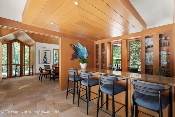 a dining room with furniture and large windows