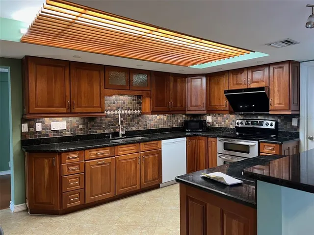 a kitchen with stainless steel appliances granite countertop a stove and a sink