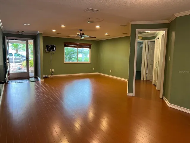 an empty room with wooden floor and windows