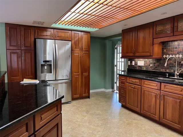 a kitchen with stainless steel appliances granite countertop a refrigerator and a sink