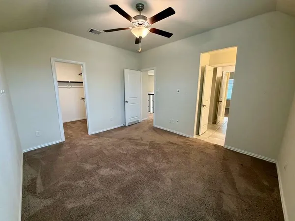 an empty room with windows and fan