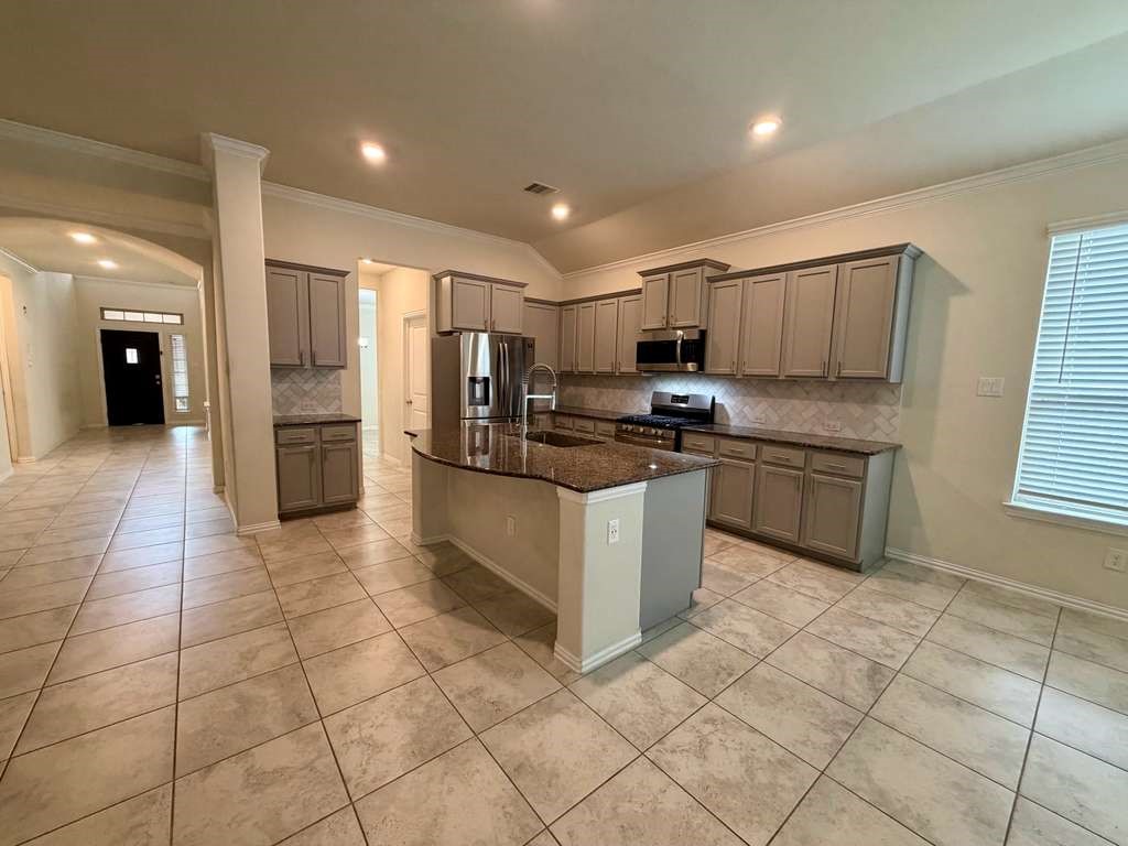 28614 Oakmist Point Lane Katy, TX 77494 - Photo 6 of 42 a kitchen with stainless steel appliances a stove a sink a microwave a counter top space cabinets and a window
