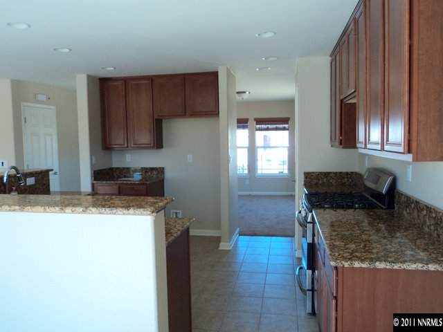 8910 Yeager Street Reno, NV 89506 - Photo 5 of 13 a kitchen with granite countertop a sink stove and cabinets