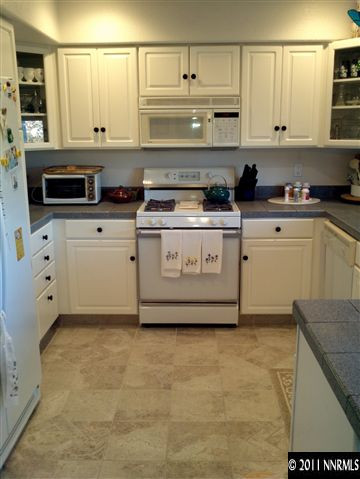 60 Ghost Rider Drive Reno, NV 89511 - Photo 2 of 13 a kitchen with granite countertop white cabinets and white appliances