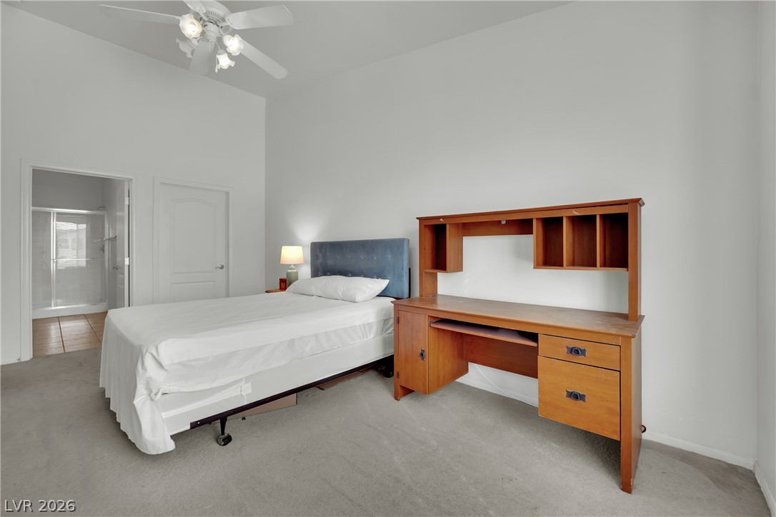 2305 West Horizon Ridge Parkway, Unit 2722 Henderson, NV 89052 - Photo 14 of 23 Bedroom featuring light carpet, a ceiling fan, a high ceiling, and ensuite bath