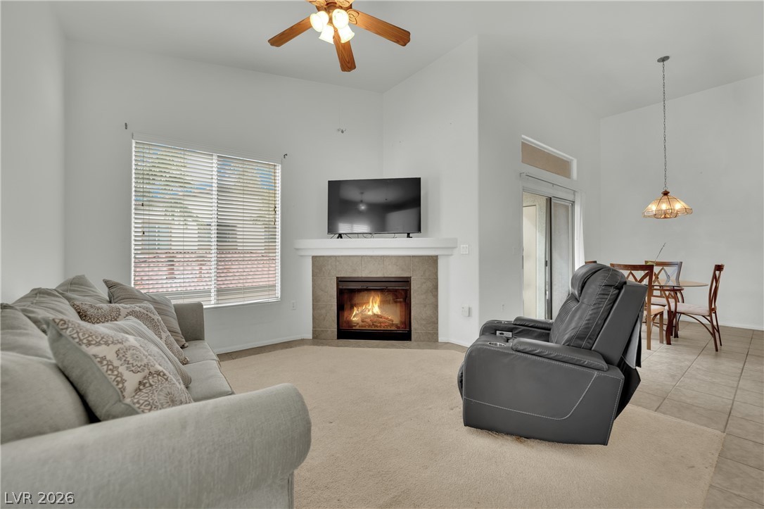 2305 West Horizon Ridge Parkway, Unit 2722 Henderson, NV 89052 - Photo 3 of 23 Living room featuring a tile fireplace, a high ceiling, and a ceiling fan