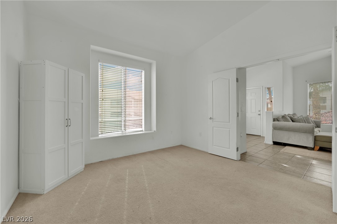 2305 West Horizon Ridge Parkway, Unit 2722 Henderson, NV 89052 - Photo 6 of 23 Bedroom with light colored carpet and lofted ceiling