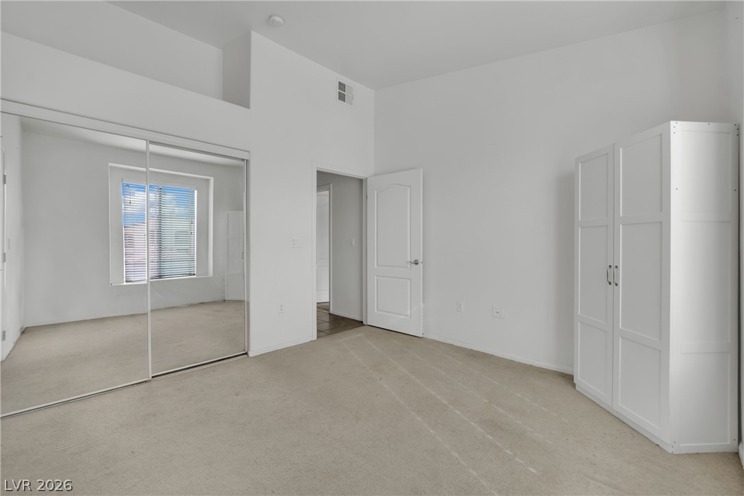2305 West Horizon Ridge Parkway, Unit 2722 Henderson, NV 89052 - Photo 7 of 23 Unfurnished bedroom with light carpet, a closet, and a high ceiling