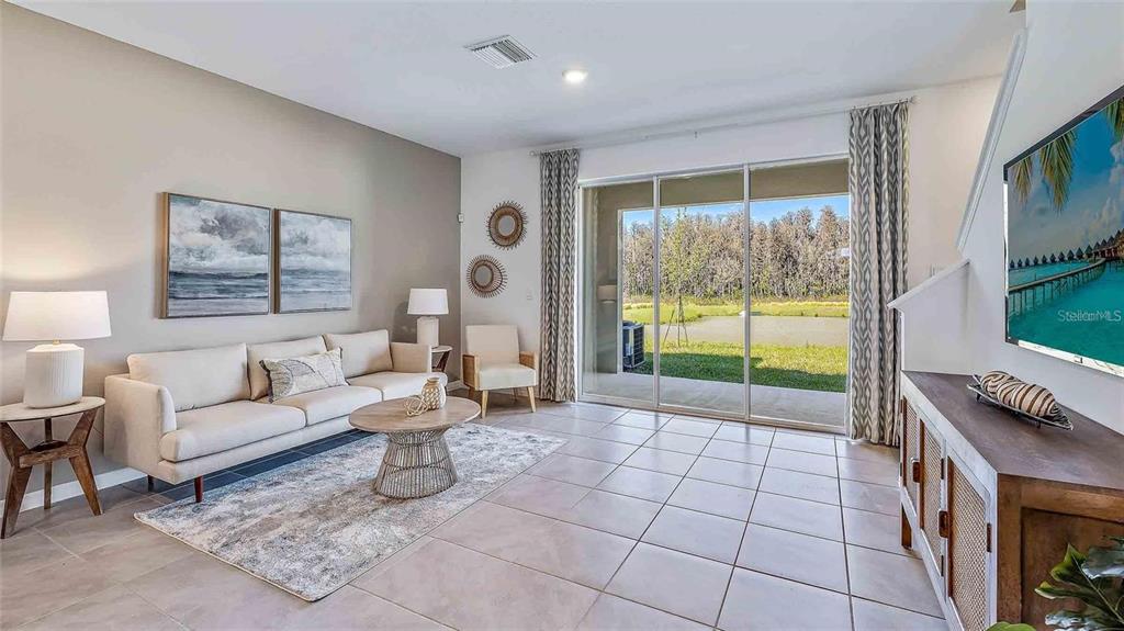 32395 Turtle Grace Loop Wesley Chapel, FL 33545 - Photo 33 of 39 a living room with furniture and a flat screen tv