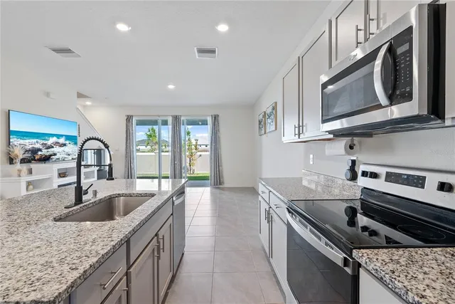 a kitchen with stainless steel appliances granite countertop a sink stove and microwave