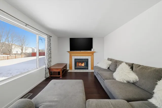 a living room with furniture a fireplace and a flat screen tv