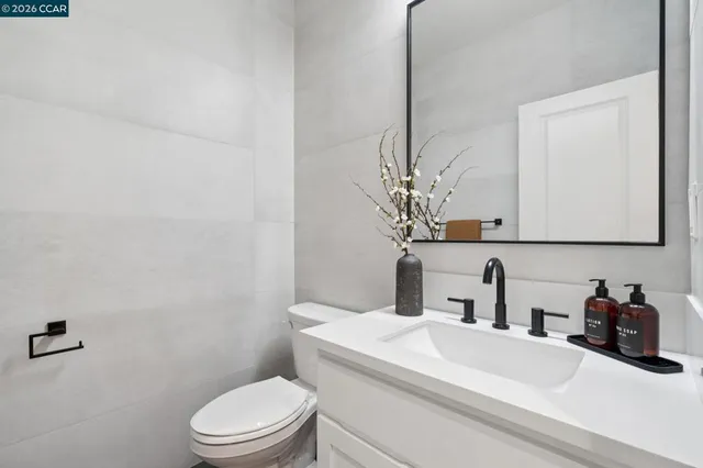 a bathroom with a sink a toilet and mirror