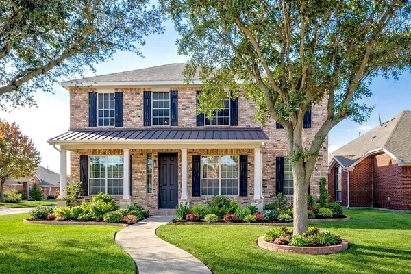 front view of a brick house with a yard