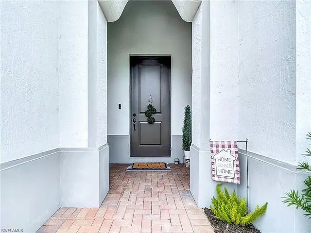 a view of a hallway with wooden floor and a living room