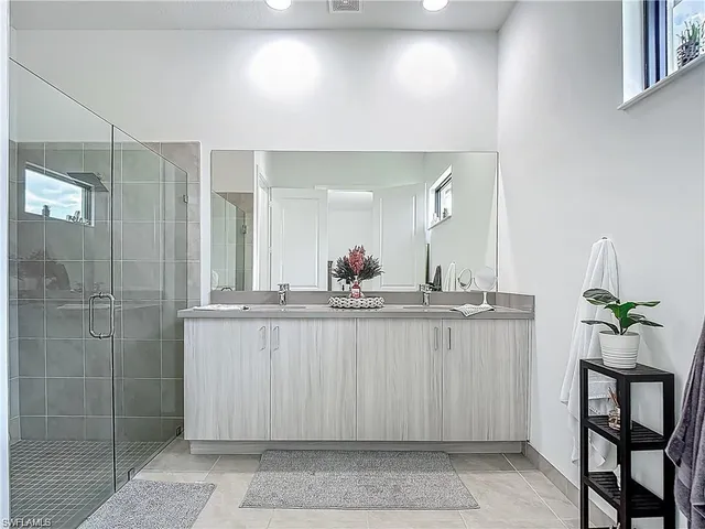 a bathroom with a granite countertop sink a toilet a mirror and shower