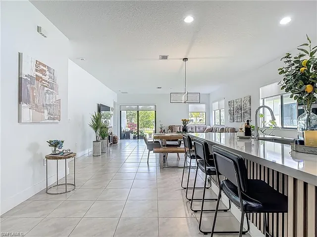 a view of a dining room and livingroom with furniture wooden floor a chandelier