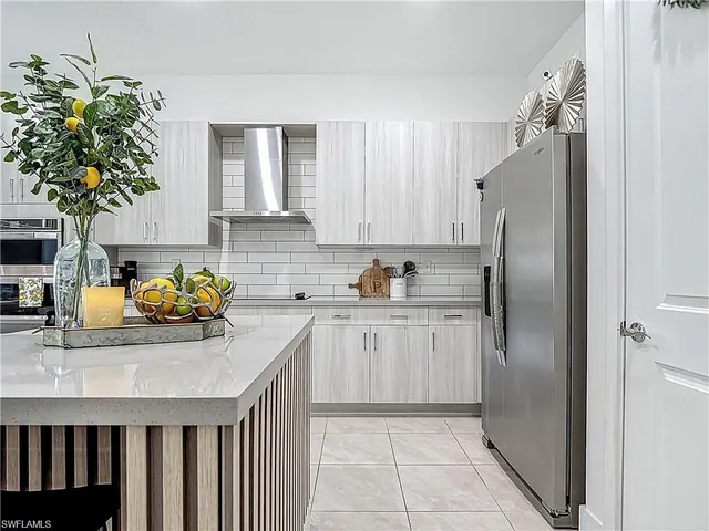 a kitchen with stainless steel appliances a sink a refrigerator a counter top space and cabinets