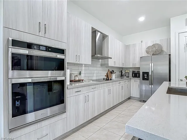 a kitchen with stainless steel appliances kitchen island granite countertop white cabinets a sink and dishwasher