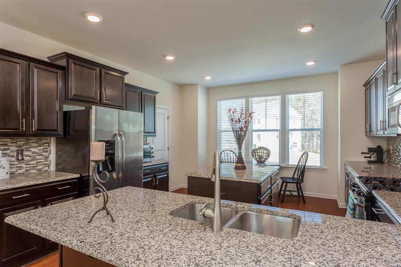 605 Edgewater Ridge Court Apex, NC 27523 - Photo 2 of 25 The kitchen has granite countertops, tile backsplash, and tons of storage space, including a pantry.