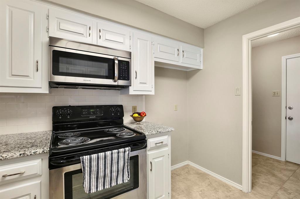 1916 Everglade Court Grapevine, TX 76051 - Photo 14 of 35 a kitchen with stainless steel appliances granite countertop white cabinets and black appliances