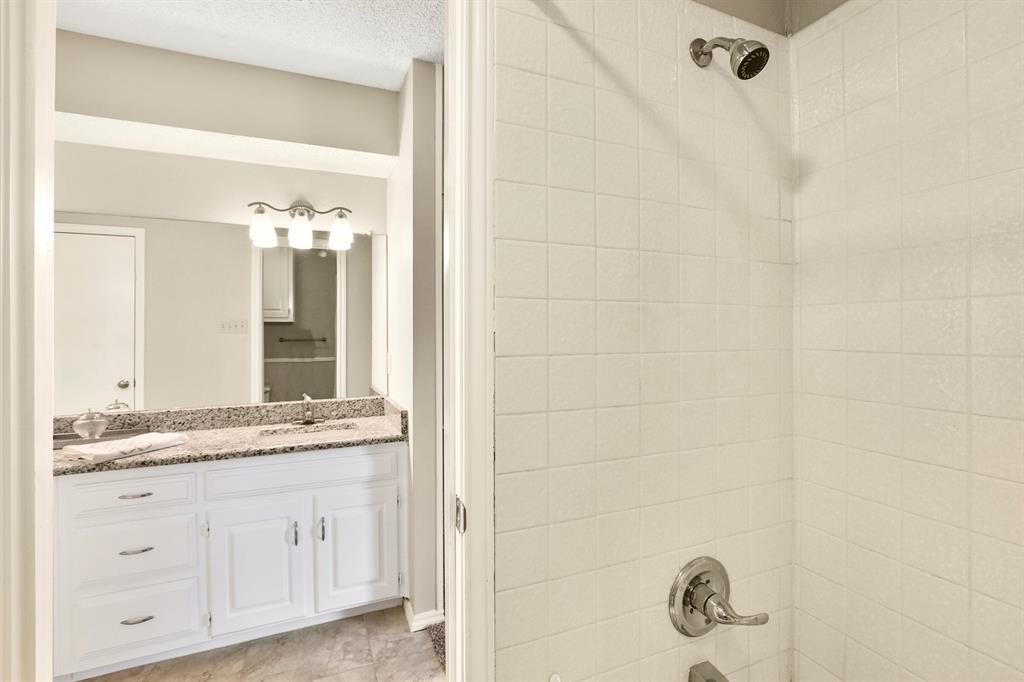 1916 Everglade Court Grapevine, TX 76051 - Photo 25 of 35 a bathroom with a granite countertop sink a mirror and a shower
