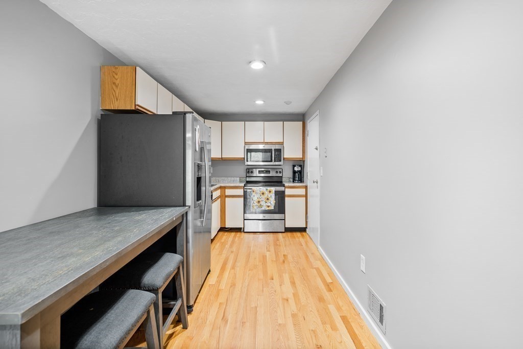 189 Littleton Road, Unit 44 Chelmsford, MA 01824 - Photo 3 of 20 a kitchen with wooden floor and stainless steel appliances