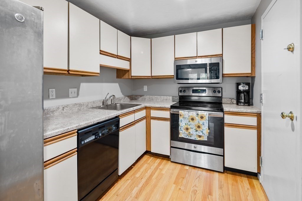 189 Littleton Road, Unit 44 Chelmsford, MA 01824 - Photo 4 of 20 a kitchen with stainless steel appliances granite countertop a stove a sink dishwasher and a refrigerator
