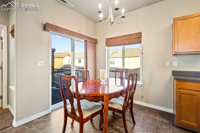a dining room with furniture a chandelier and wooden floor