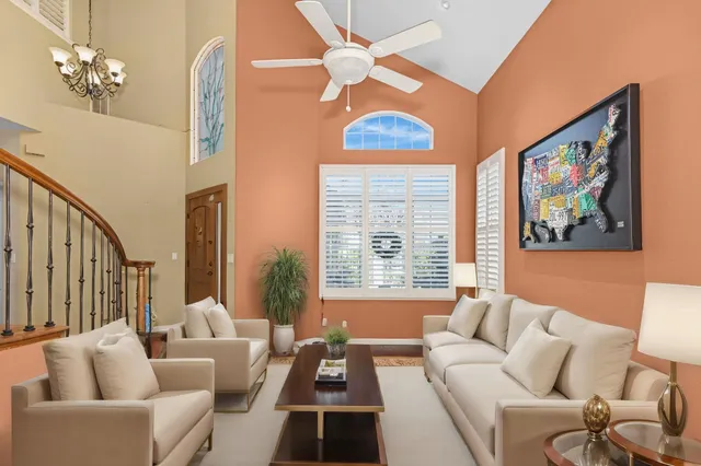 a living room with furniture a chandelier and a large window