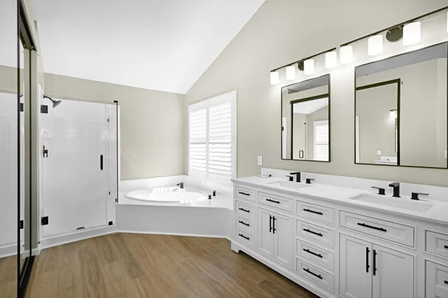 a bathroom with a double vanity sink mirror double and bathtub