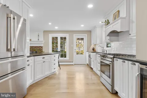 a large kitchen with stainless steel appliances granite countertop a stove a sink and a refrigerator