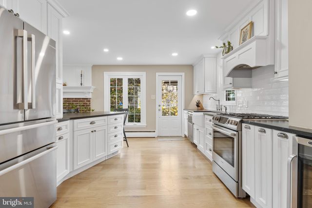 a large kitchen with stainless steel appliances granite countertop a stove a sink and a refrigerator