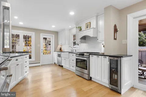 a kitchen with stainless steel appliances white cabinets and wooden floor