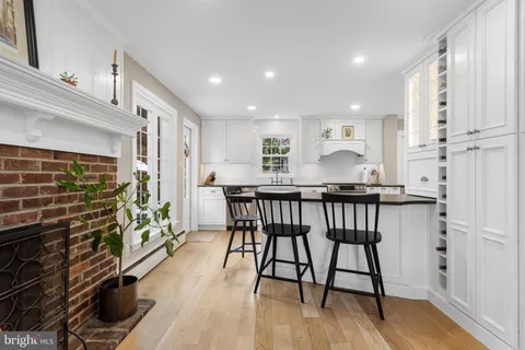 a kitchen with stainless steel appliances kitchen island granite countertop a table chairs in it and wooden floors