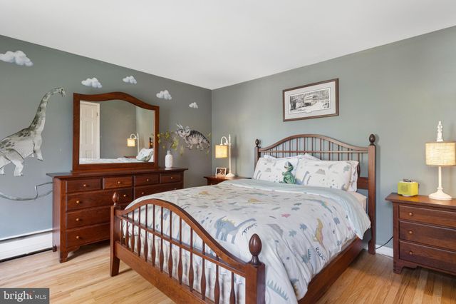 a bedroom with a bed a mirror on dresser and a window