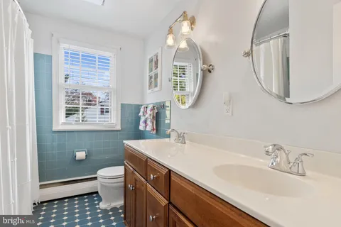 a bathroom with a sink a toilet and a mirror